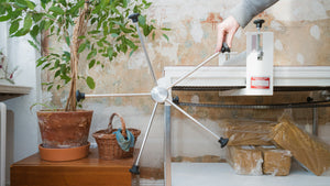 A ceramic pitcher is being made by an artist  holding fine tools.